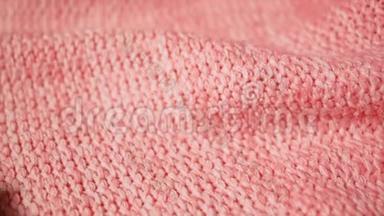 针织布，柔软的粉红色珊瑚色。 女人`手触摸手工时尚的美利奴面料.. 检查织物